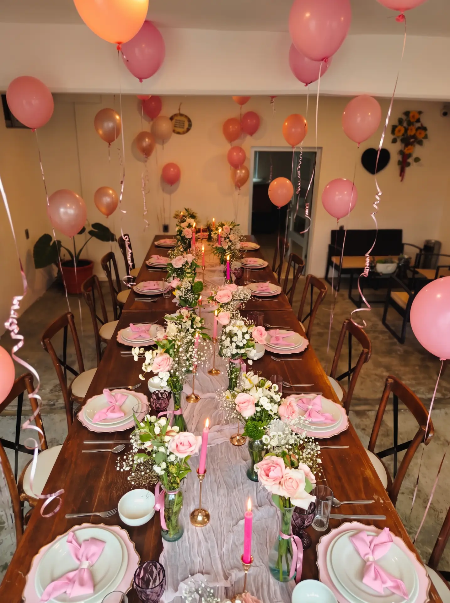 Mesa de celebración con globos rosas y velas