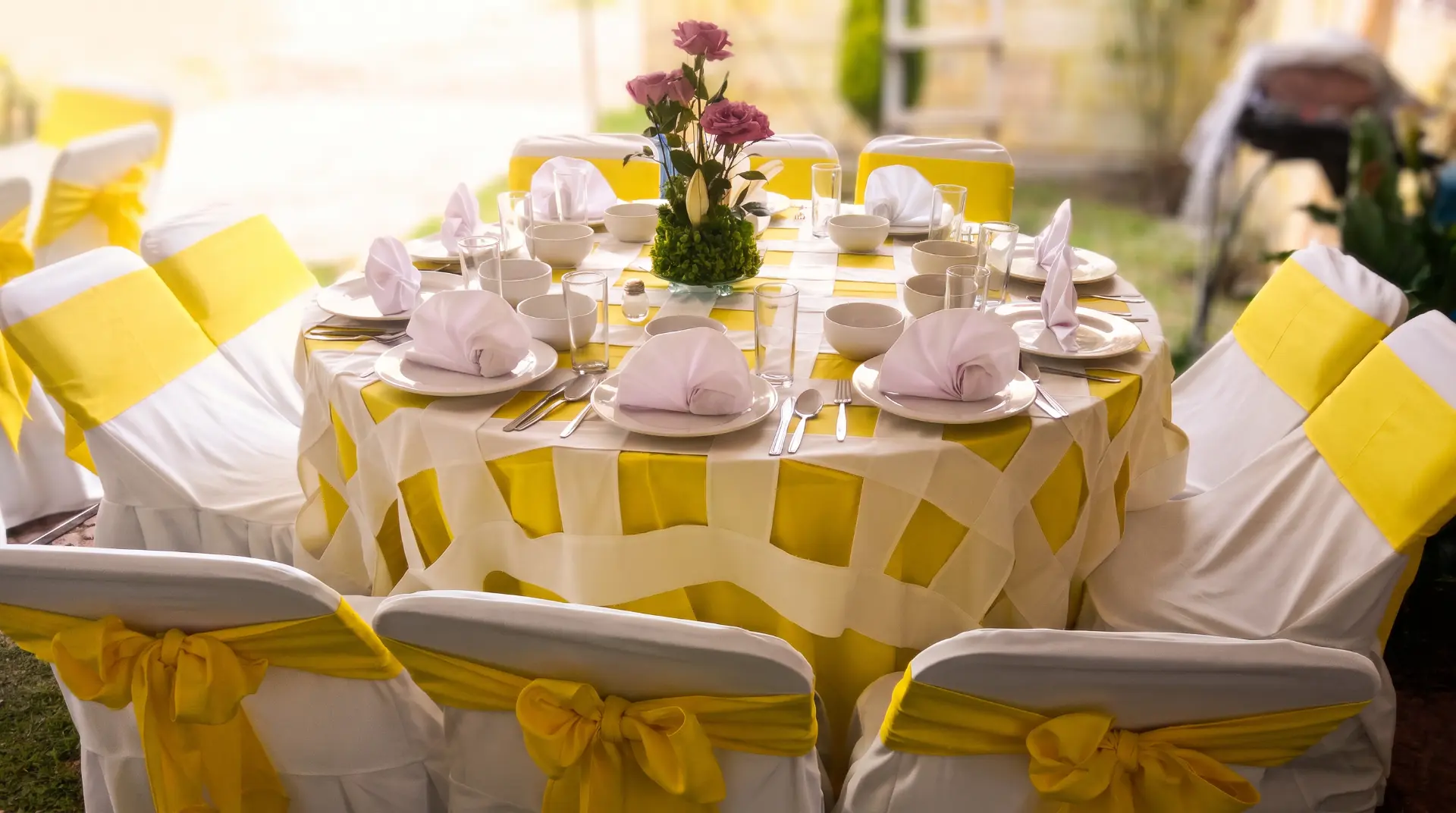Mesa con mantelería amarilla y centro floral