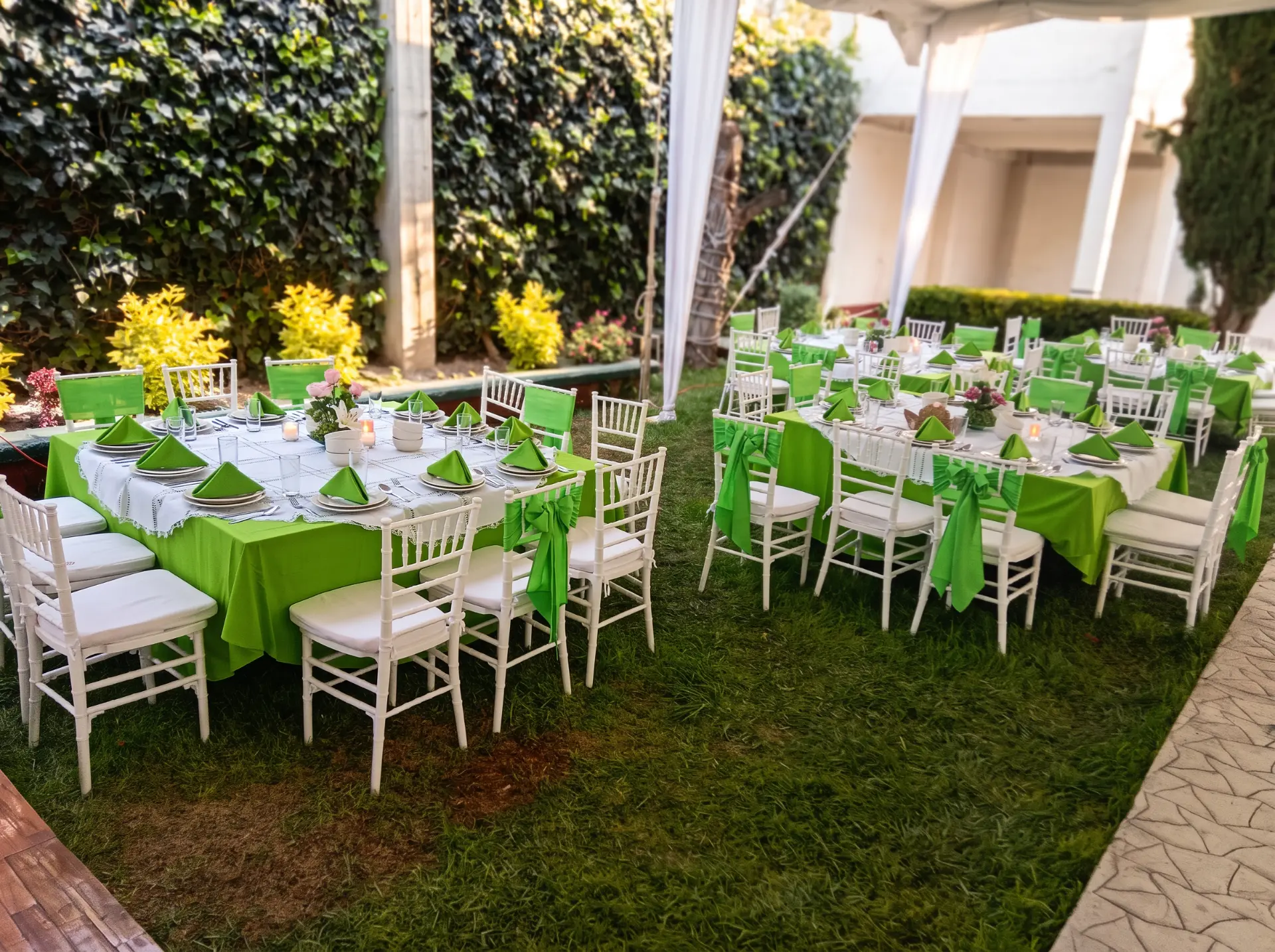 Mesas en jardín con mantelería verde